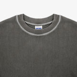 Close-up of a dark gray waffle-knit crewneck sweater with a ribbed collar and a visible Dri-Wax label inside the neckline.