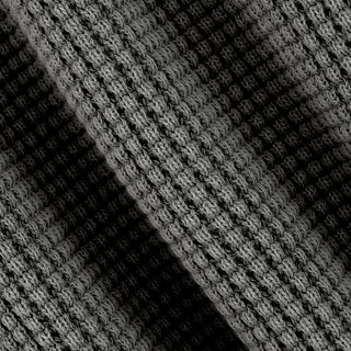 Close-up of a black and gray textured knit fabric with a diagonal shadow creating contrast.