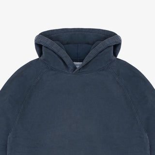 Close-up of a dark slate blue hooded sweatshirt showing the hood and upper chest area against a light gray background.