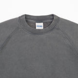 Close-up of a dark gray crewneck sweatshirt with raglan sleeves, showing the inner neck label with the brand name 'DIRTWEAR'.