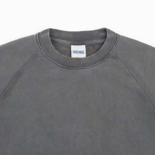 Close-up of a dark gray crewneck sweatshirt with raglan sleeves, showing the inner neck label with the brand name 'DIRTWEAR'.