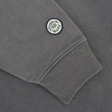 Close-up of a dark gray sweatshirt sleeve featuring a ribbed cuff and a circular embroidered patch that reads 'CUBIK WARS' with a green globe logo.