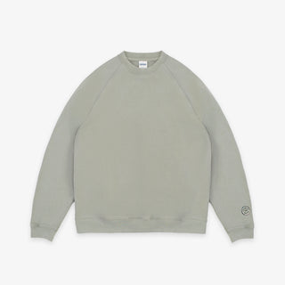 A light sage green crewneck sweatshirt with raglan sleeves, laid flat against a clean white background.
