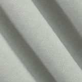 A close-up of draped light sage green knit fabric showing its fine woven texture and soft folds.