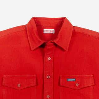 A close-up of a red Doubleware button-up shirt showing the collar, front buttons, and two chest pockets with button-flap details on a light gray background.