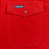 A close-up of a bright red fabric pocket with a flap closure and a small button, featuring a visible DUBBLEWARE label.