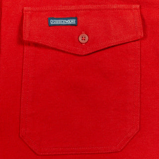 A close-up of a bright red fabric pocket with a flap closure and a small button, featuring a visible DUBBLEWARE label.