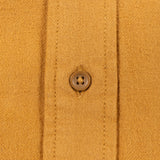 Close-up of a mustard yellow knit fabric garment with a single brown button on the front placket.