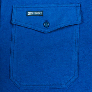 A close-up of a vibrant royal blue fleece or sherpa fabric pocket with a buttoned flap and a visible 'DUBBLEWARE' brand label.