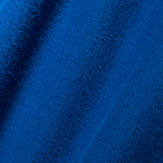 A close-up of textured royal blue fabric with soft folds and a woven or terry-like surface.