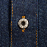 Close-up of a dark blue denim button-up shirt featuring orange contrast stitching and a silver metal button engraved with 'DUBBLEWARE'.