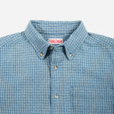 A light blue and white checkered long-sleeve button-down shirt with a chest pocket, displayed flat against a light gray background.