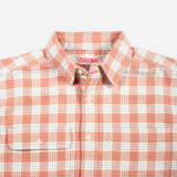 A close-up of a Doubleware button-down shirt featuring a peach-orange and white plaid pattern, with a visible brand label inside the collar.