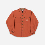 An orange long-sleeve button-up shirt with two chest pockets, laid flat on a light gray background.