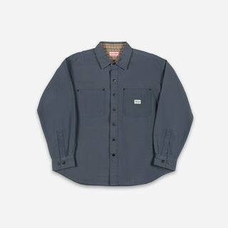 A dark slate blue long-sleeve button-up shirt with two chest pockets, laid flat against a light gray background.